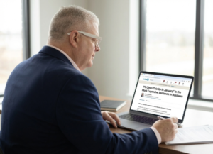 Brian Giesler sitting at his desk reading a LinkedIn article about Year-End Bookkeeping